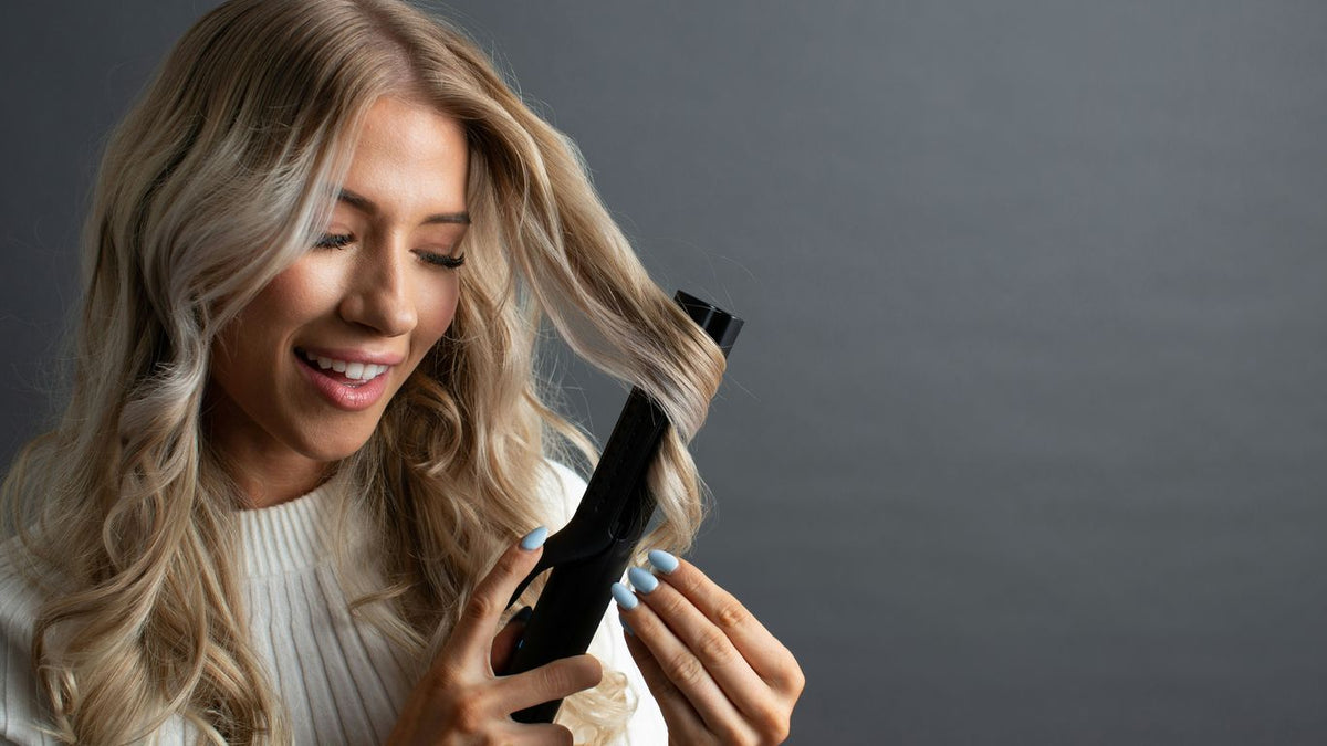 a woman holding a hair dryer and combing her hair